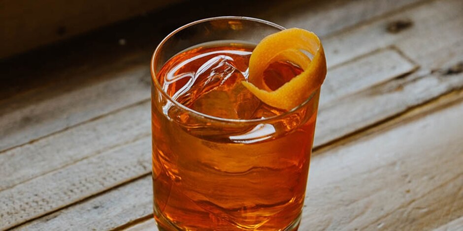 Cheeky Negroni cocktail in a rocks glass, served over ice with an orange twist.